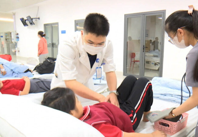 Bác  sỹ thăm khám cho học sinh bị nghi là ngộ độc